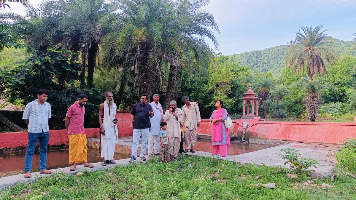 Community members gathered at a sacred water source beside an oran
